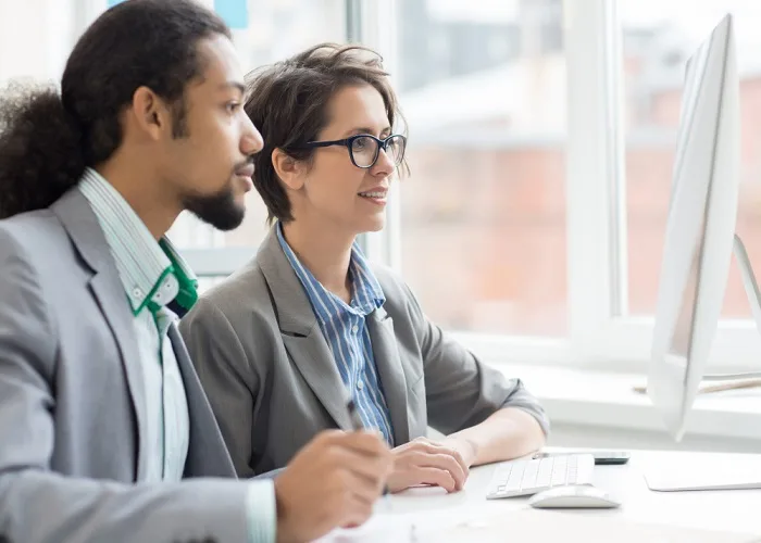 Two assessment professionals reviewing information together on a computer