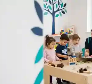 Early years practitioner supporting children during a nursery activity